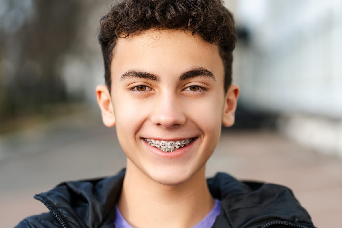 Teen smiling with metal braces outdoors
